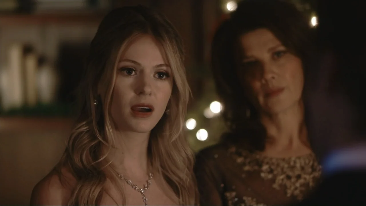 Driving Madeleine (2022) movie still: medium — An interior domestic space decorated with out-of-focus background holiday lights. A young woman looks…