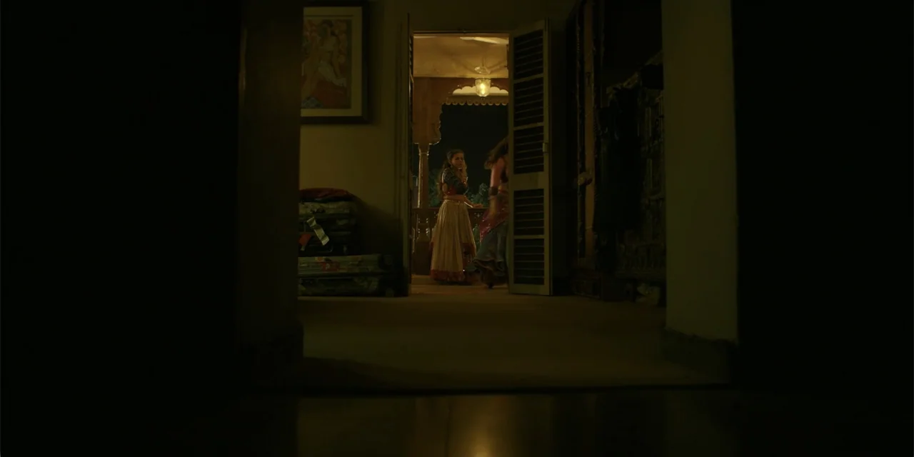 Maja Stoneface (1996) movie still: wide — A darkened interior room looks out through an open doorway onto a lit veranda. Two women stand on the…
