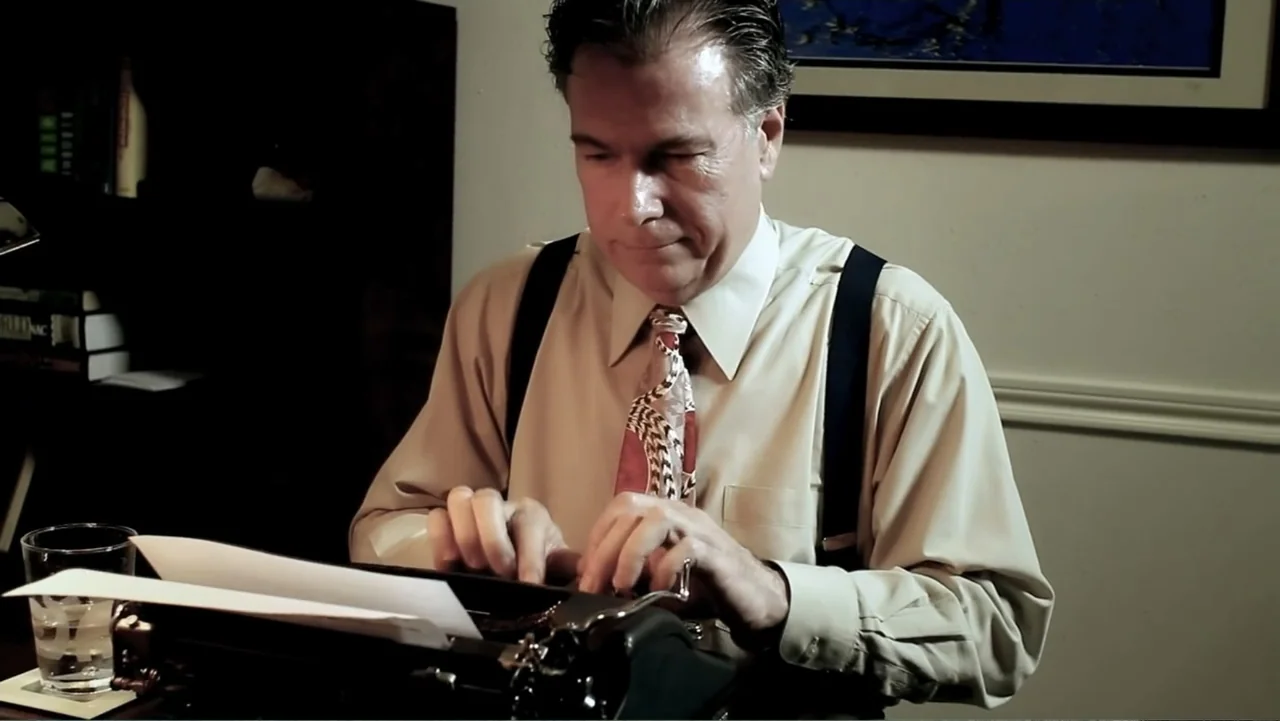 UFO Conspiracies: The Hidden Truth (2020) movie still: medium — A dimly lit home office features a desk with a vintage typewriter and books. A…