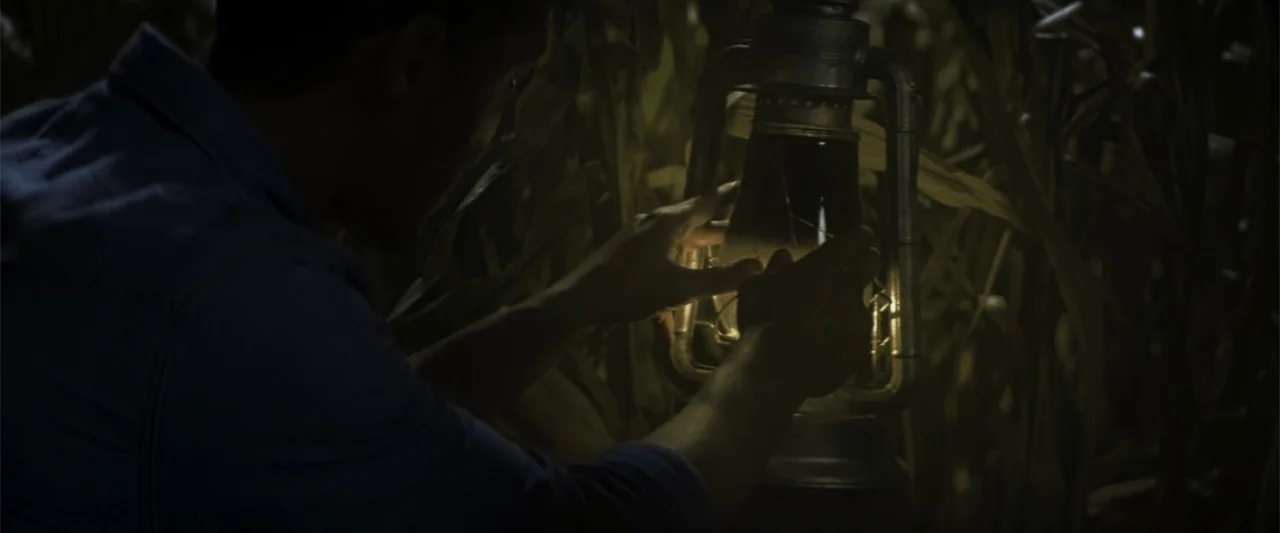 Treblinka's Last Witness (2012) movie still: medium — A dark cornfield at night provides the backdrop for a man holding a lantern. A person is shown…
