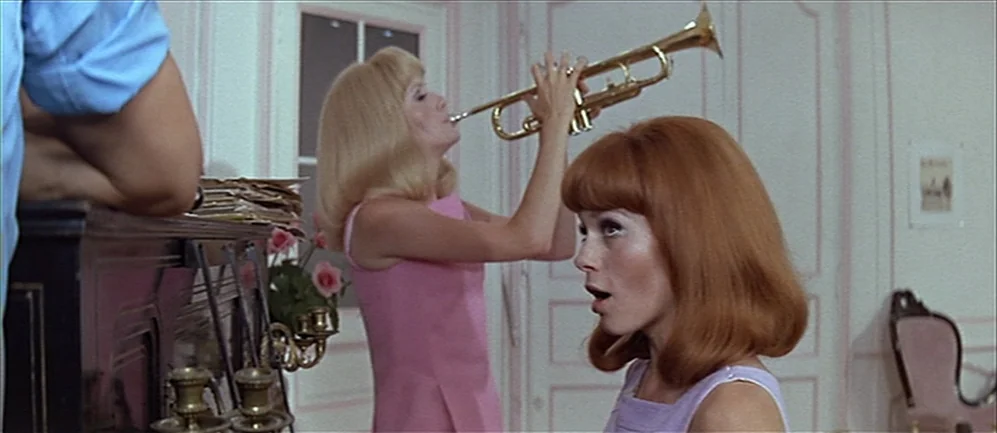 Les Demoiselles de Rochefort (1967) movie still: medium — An interior space features two young women in a pastel-colored room with white doors. One…