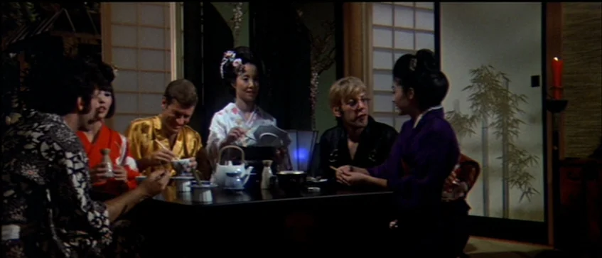MASH (1970) movie still: medium — A dark dining room with shoji screens in the background and a low table. Six people in kimonos and western…