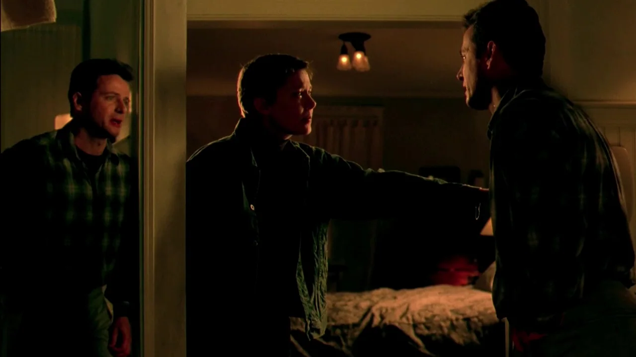 In Dreams (1999) movie still: medium — Two men and one woman stand in the transition between a hallway and bedroom. The woman reaches out to touch…
