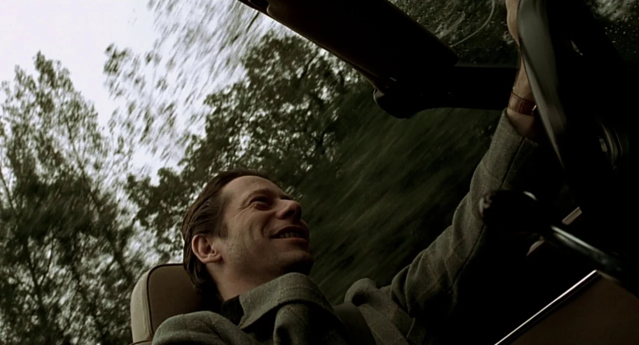 The Diving Bell and the Butterfly (2007) movie still: medium — A man drives a car through a landscape of blurred, motion-streaked trees. The…