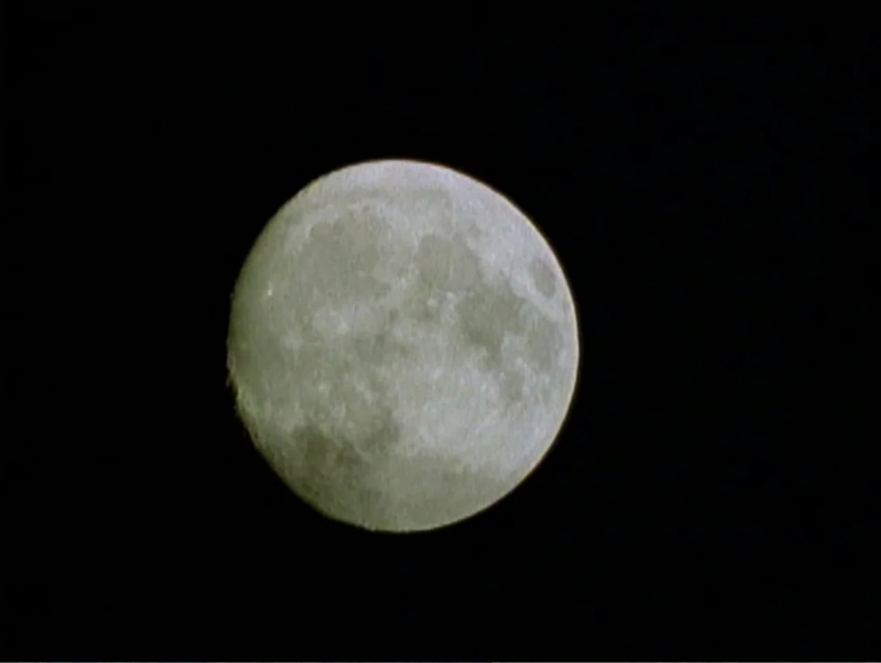 America Undercover: Life Afterlife (2000) movie still: closeup — A full moon sits isolated in the darkness of the night sky. The textured lunar…