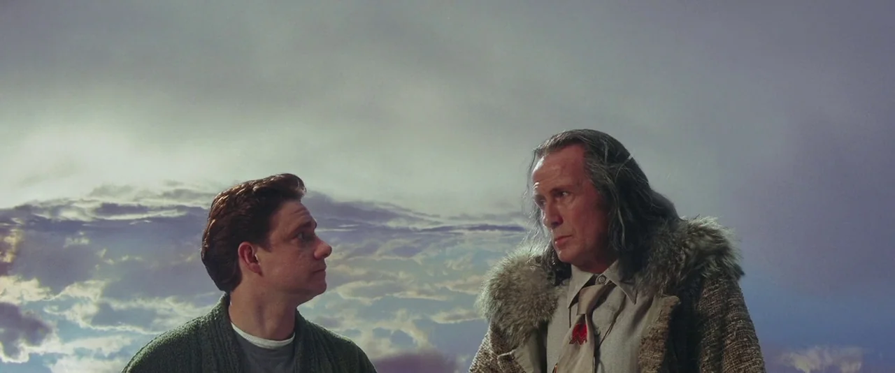 A Hitchhiker’s Guide To The Galaxy (2005) movie still: medium — Two men stand against a backdrop of vast, cloud-filled sky. They appear to be…