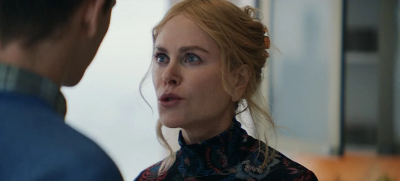 Babygirl (2024) movie still: closeup — An indoor office environment with out-of-focus background details suggesting a corporate workspace. A blonde…