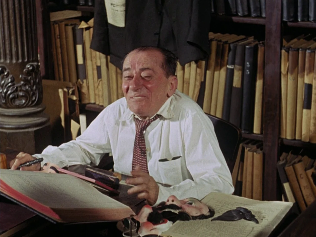 Black Orpheus (1959) movie still: medium — A cluttered archival workspace features floor-to-ceiling wooden bookshelves filled with bound record…