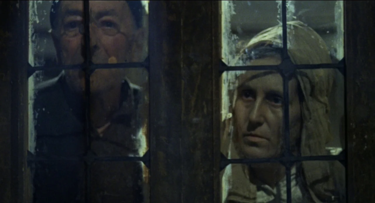 Beatrice Cenci (1969) movie still: medium — A man and woman watch through a dark window with heavy leaded glass muntins. They stand side by side in…