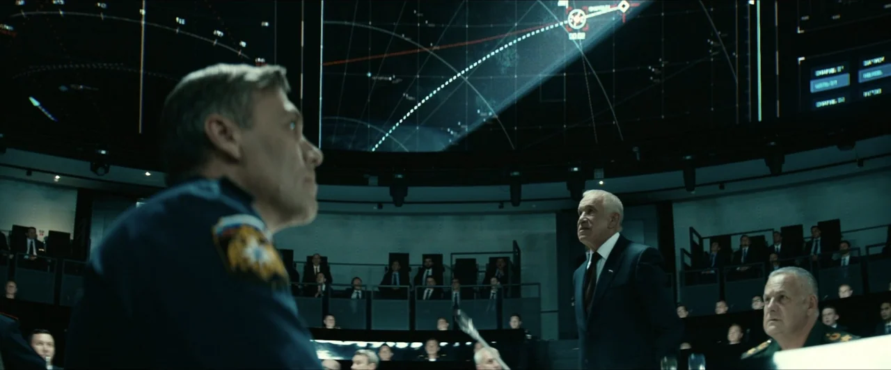 Invasion (2020) movie still: medium — A dark, circular military command center features a massive glowing wall-mounted tactical display map. An…