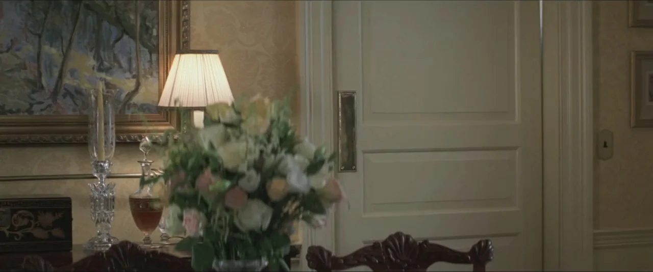 Maid in Manhattan (2002) movie still: establishing — A well-appointed interior features pale floral wallpaper and a classic white panel door. A…