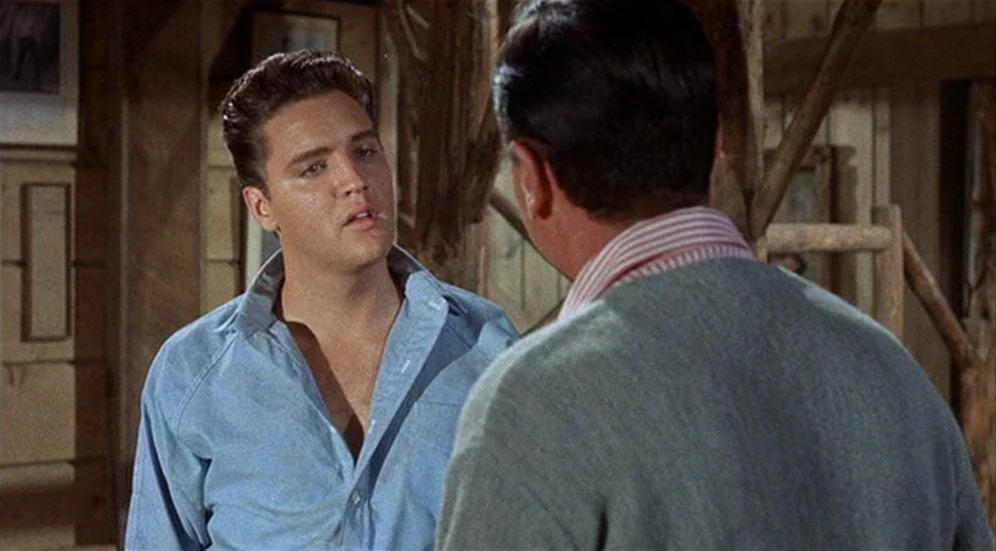 Kid Galahad (1962) movie still: medium — A rustic wooden interior with light colored timber walls and exposed wooden beams. Elvis Presley is in the…