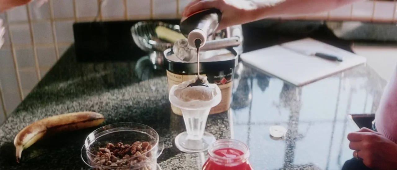 Pretty Persuasion (2005) movie still: closeup — A polished dark granite surface serves as a preparation area with assorted food items. A hand pours…