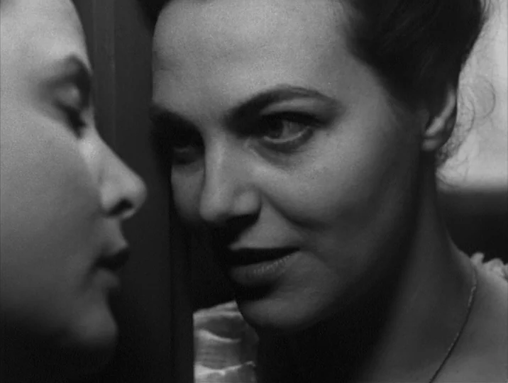 Thirst (1949) movie still: closeup — A close-up shot of two women positioned face to face in a dim environment. One woman observes the other while…