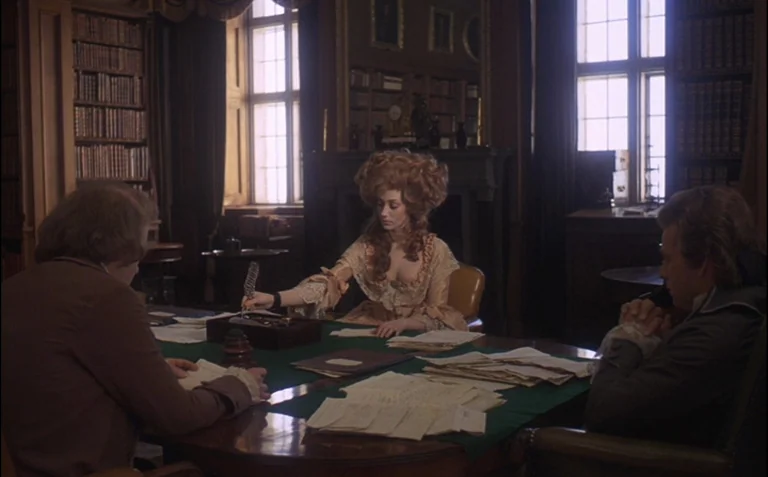 Barry Lyndon (1975) movie still: wide — A wood-paneled library with floor-to-ceiling bookshelves and large windows. Three people sit around a long…