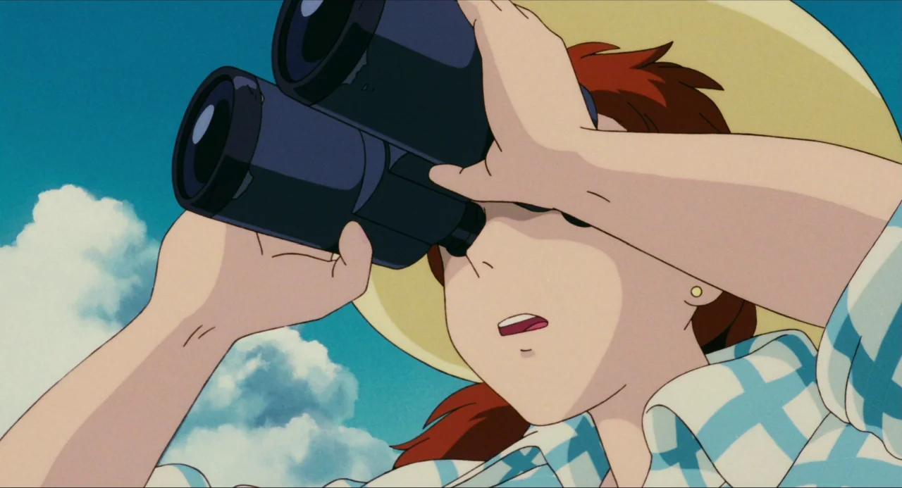 Porco Rosso (1992) movie still: closeup — A clear blue sky with white clouds serves as the backdrop. A woman looks through black binoculars while…