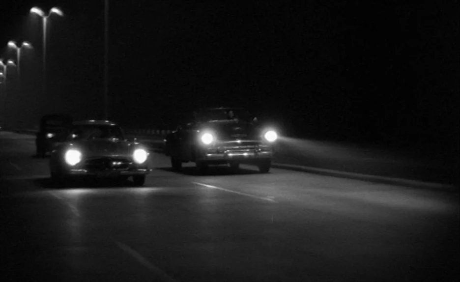 Elevator To The Gallows (Ascenseur pour l’échafaud) (1958) movie still: wide — A dark, empty multi-lane highway is illuminated only by the…