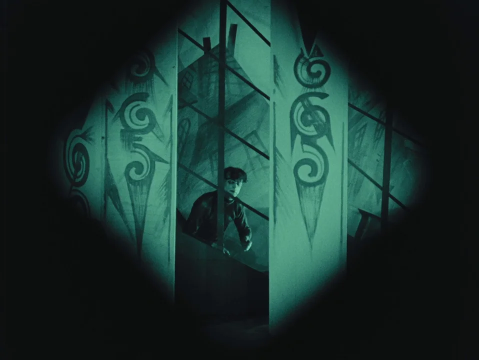 The Cabinet of Dr. Caligari (1920) movie still: medium — A German Expressionist set features stylized, jagged painted walls and steep angular…