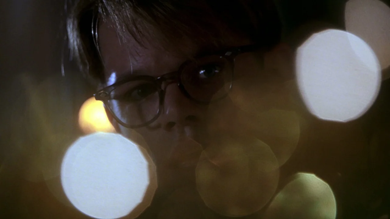 The Talented Mr. Ripley (1999) movie still: closeup — A dimly lit interior space features large out-of-focus light orbs in the foreground. A man…