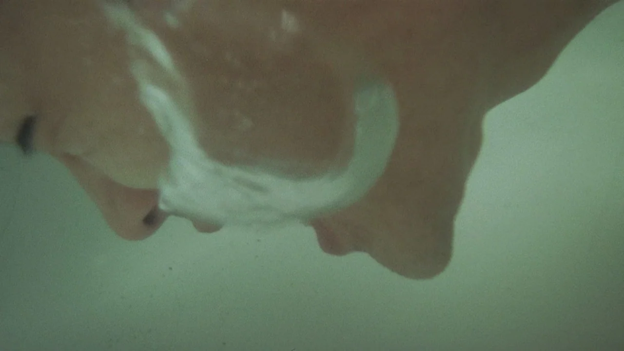 Peppermint Candy (1999) movie still: closeup — A close perspective reveals a person's profile submerged just below a greenish water surface. Air…