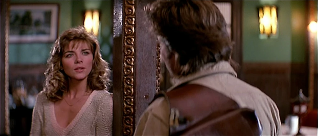 Big Trouble in Little China (1986) movie still: medium — A dimly lit establishment with green walls and dark wood accents. A man faces a woman…
