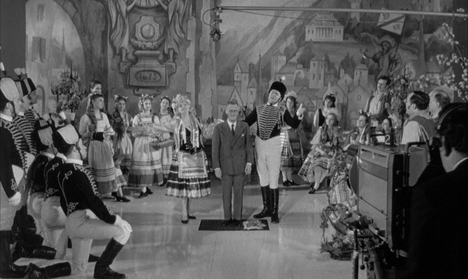 A Hard Days Night (1964) movie still: wide — A film studio sound stage features a painted backdrop of a medieval village setting. A group of…