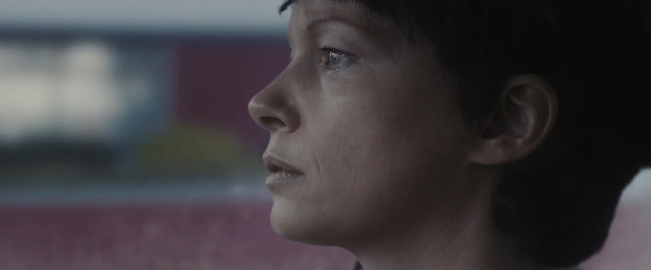 You Are Not My Mother (2021) movie still: closeup — A close-up shot of a woman seen from the side inside a vehicle cabin. The subject stares ahead…