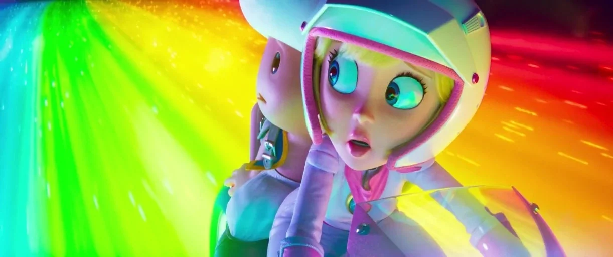 The Super Mario Bros. Movie (2023) movie still: medium — A vibrant rainbow-colored track swirls around a character on a motorcycle at high speed.…