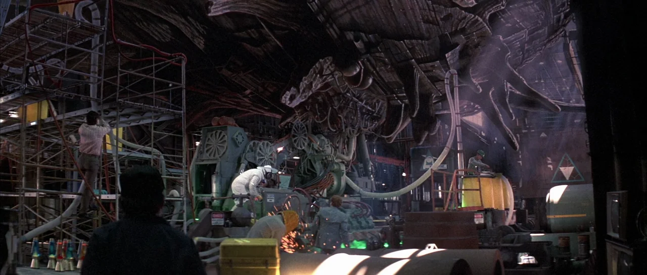The Adventures of Buckaroo Banzai Across the 8th Dimension (1984) movie still: wide — A vast industrial hangar contains scaffolding and a large,…