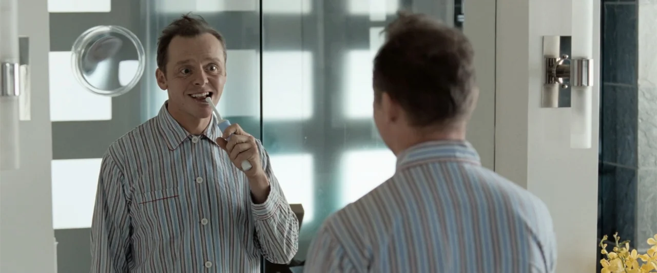 Hector and the Search for Happiness (2014) movie still: medium — A modern bathroom features a large wall mirror reflecting the standing man. The man…
