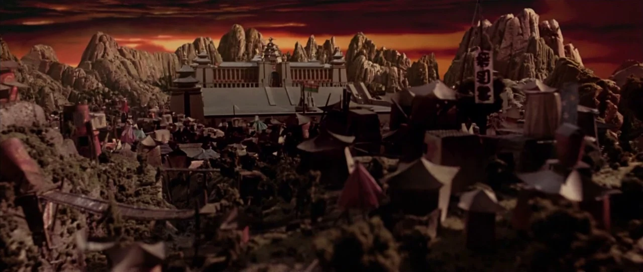 Team America: World Police movie still: establishing — A miniature landscape shows a settlement built into rocky mountains under a dark red sky.…