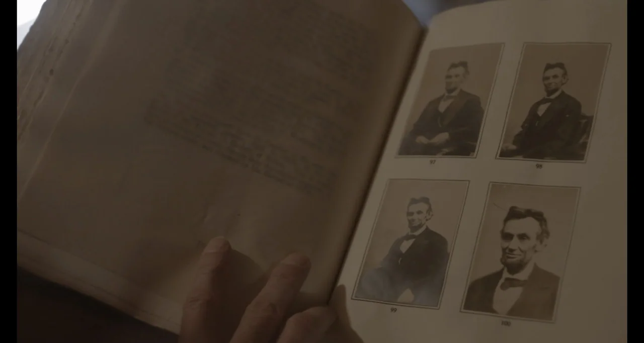 Living With Lincoln (2015) movie still: closeup — An open vintage book features several small portrait photographs of Abraham Lincoln on pages. A…