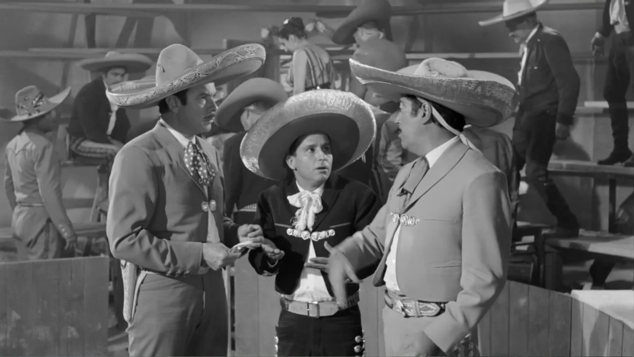 Escuela para solteras (1965) movie still: medium — A group of men in traditional Mexican charro attire stand together inside an arena. The three…