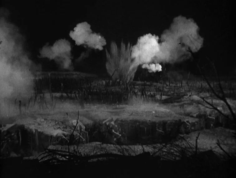 The Roaring Twenties (1939) movie still: wide — A dark, war-torn battlefield features mud, debris, and numerous explosions in the distance. The area…