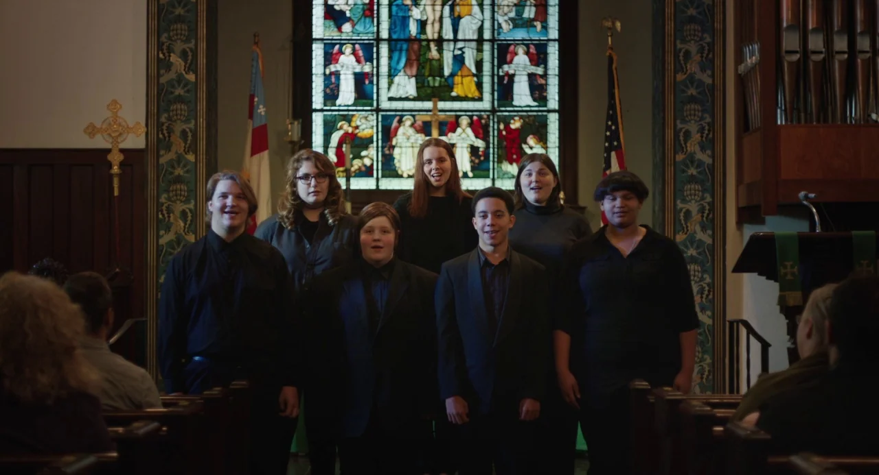 The Miseducation of Cameron Post (2018) movie still: medium — A group of teenagers stand in formation within the sanctuary of a church. They are…