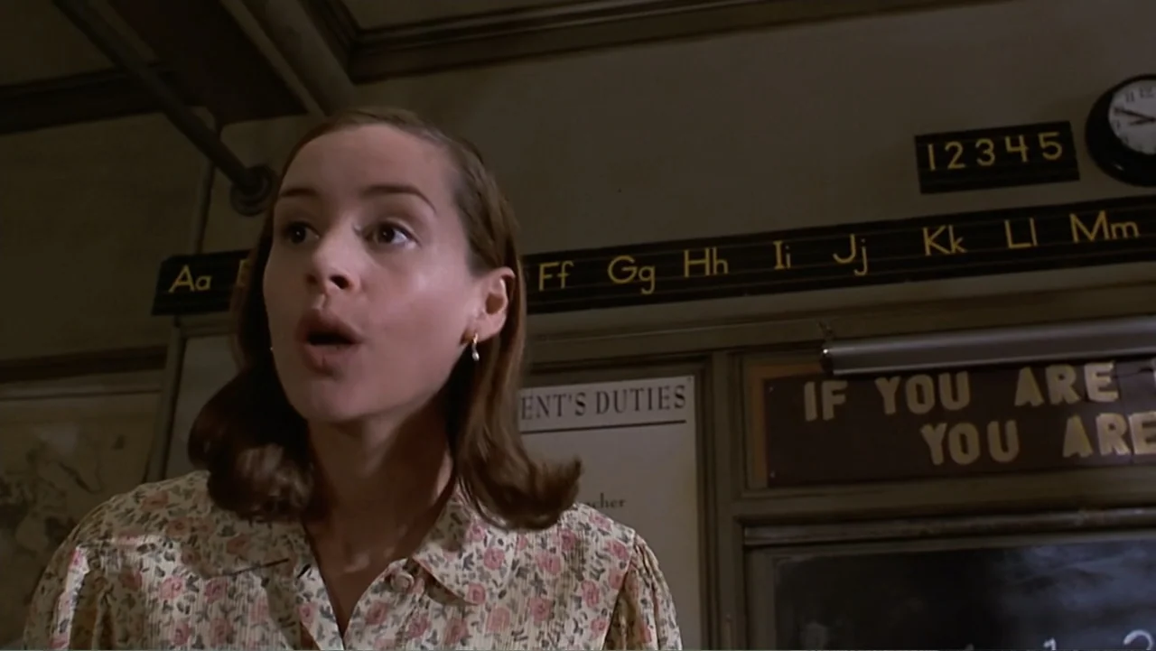 Matilda (1996) movie still: medium — A 1950s primary school classroom features educational alphabet charts and duty lists on the wall. A woman…