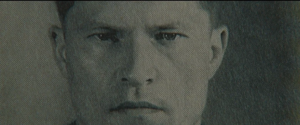 Inglourious Basterds (2009) movie still: closeup — A grainy black-and-white portrait photograph of a man with short dark hair. The subject looks…