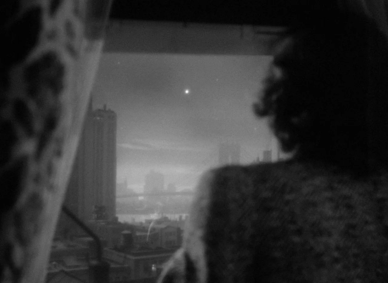 Dance, Girl, Dance (1940) movie still: medium — An interior apartment room features a large window overlooking a dark city skyline. A person stands…