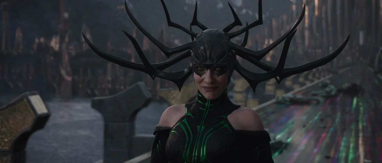 Thor: Ragnarok (2017) movie still: medium — A dark, ornate bridge stretches across a deep void beneath a somber, cloudy sky. A woman wearing a…