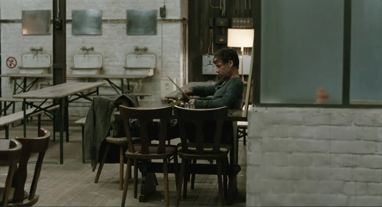 Soul Kitchen (2009) movie still: medium — A spacious mess hall features whitewashed brick walls, communal wooden tables, and rows of sinks. A…