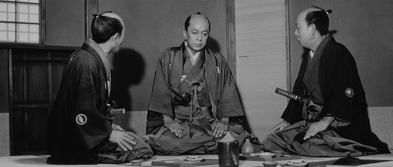 Sanjuro (1962) movie still: medium — Three men in traditional samurai clothing sit in a formal Japanese interior space. The men are arranged in a…