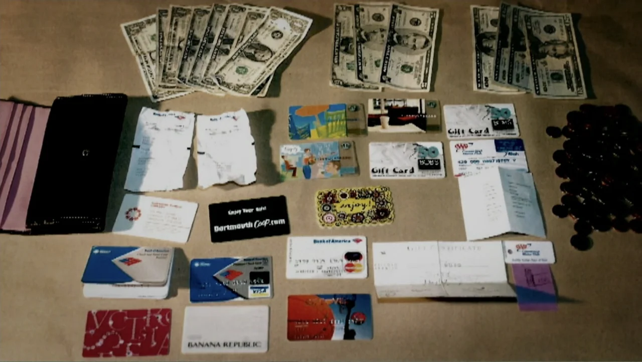 The Cheshire Murders (2013) movie still: wide — A flat brown surface contains an organized collection of American currency, receipts, and cards.…