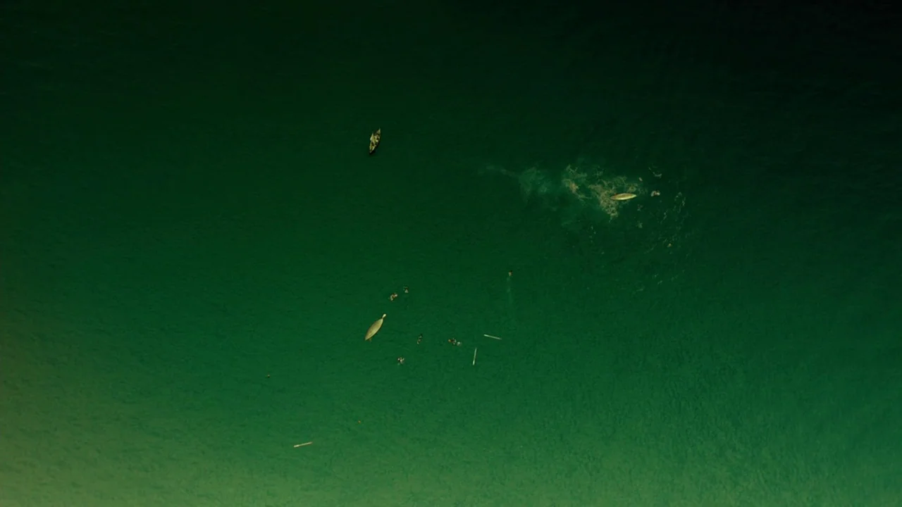 In The Heart of the Sea (2014) movie still: establishing — A vast expanse of deep green ocean stretches across the entire frame. Several small boats…