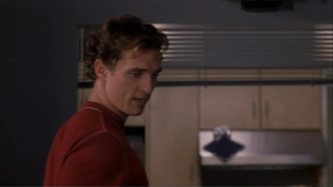 How to Lose a Guy in 10 Days (2003) movie still: medium — A modern home kitchen with light wood cabinetry and horizontal metal blinds behind him. A…