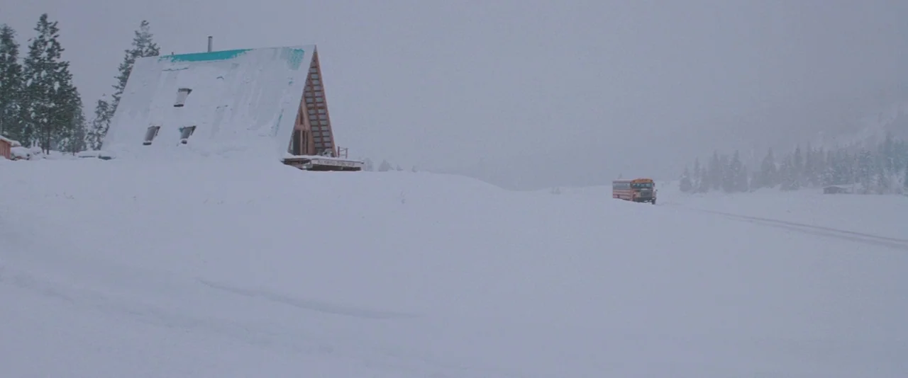The Sweet Hereafter (1997) movie still: wide — A wide, flat landscape buried under deep snow during a winter storm. A solitary yellow school bus…