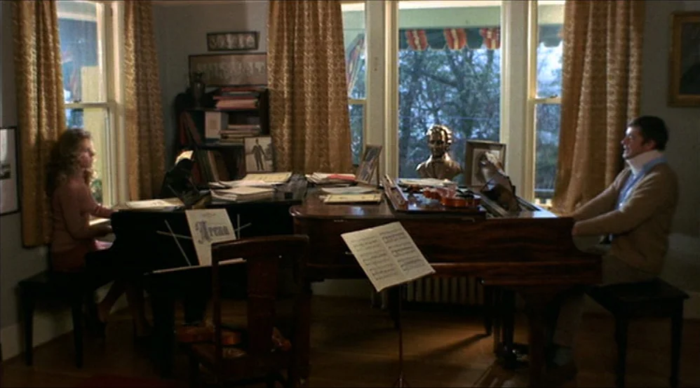 Five Easy Pieces (1970) movie still: wide — A room with two grand pianos features a large window with draped curtains. A man with a neck brace and a…