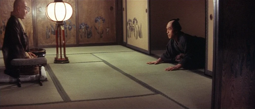 An Actor’s Revenge (1963) movie still: wide — A traditional room features tatami mats and sliding doors decorated with iris paintings. Two men sit…