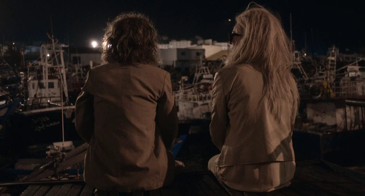 Only Lovers Left Alive (2013) movie still: medium — A harbor at night filled with numerous fishing boats illuminated by distant harbor lights. Two…