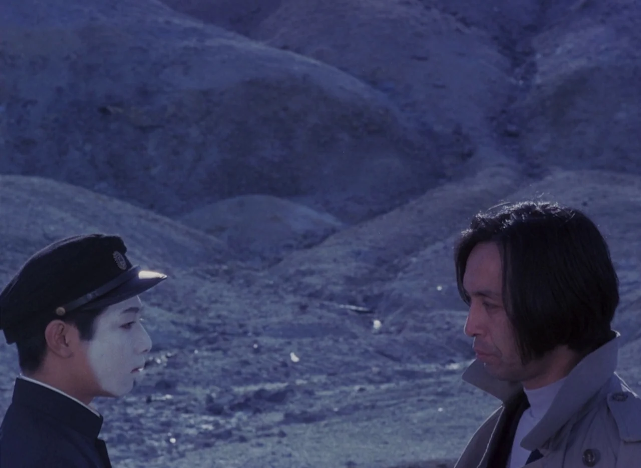 Pastoral To Die In The Country (1974) movie still: medium — A desolate desert landscape with rolling, barren sand dunes under a blue twilight sky.…