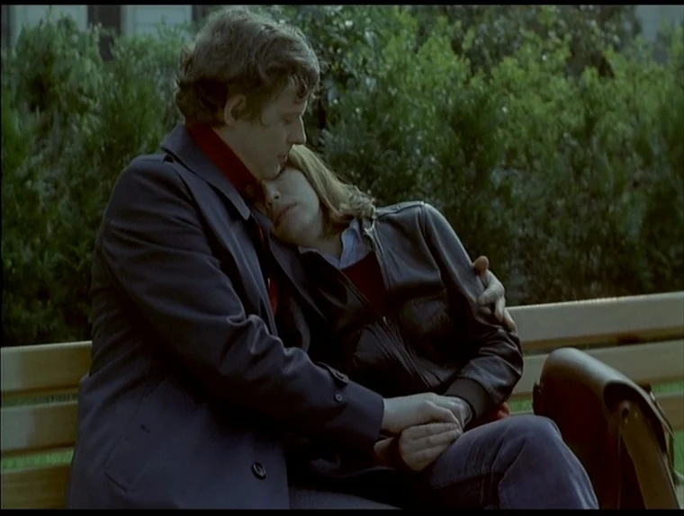 Love In The Afternoon (Chloe In The Afternoon) (L’amour l’après-midi) (1972) movie still: medium — Two individuals sit together on a wooden park…